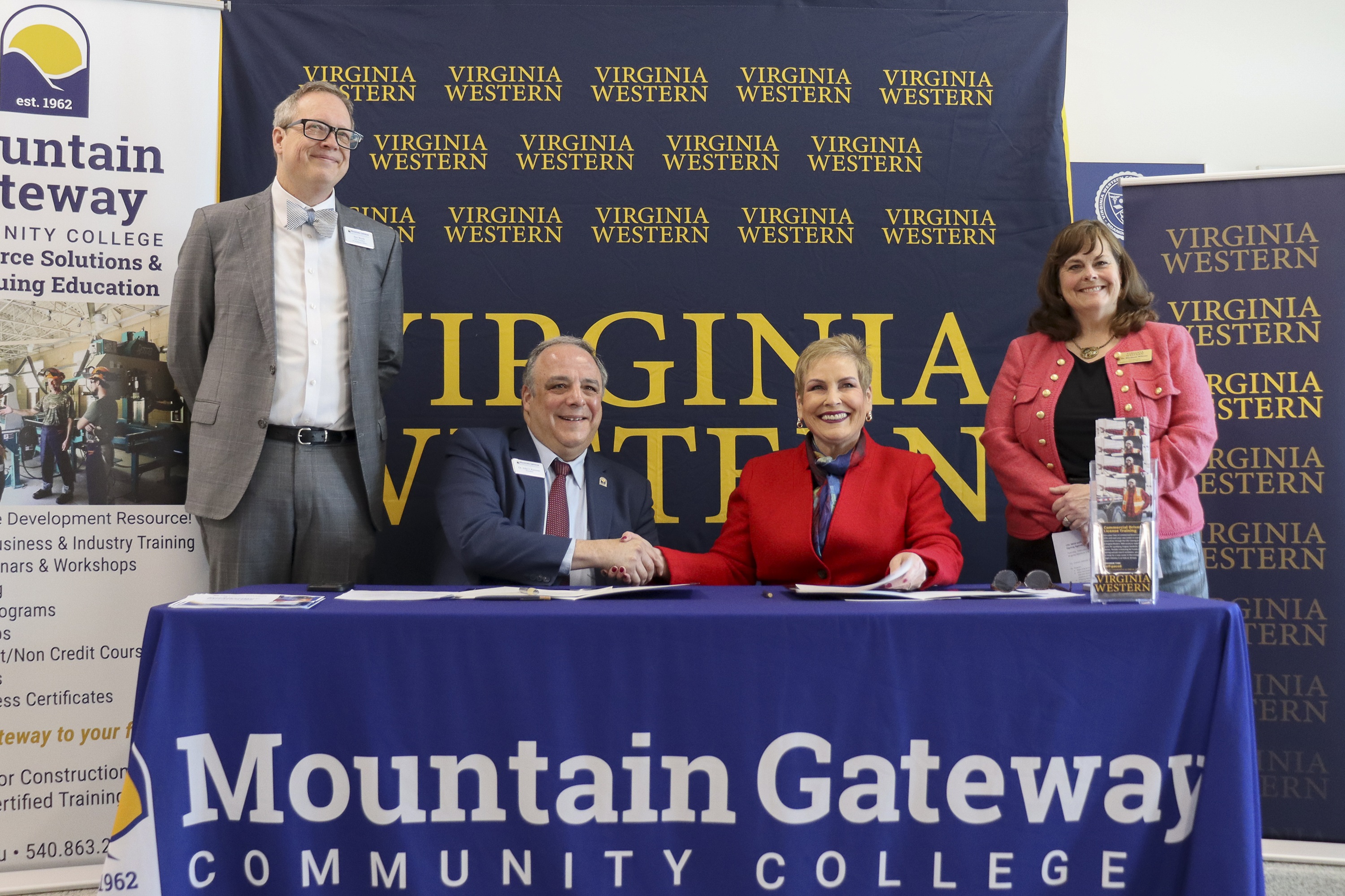 MGCC President Dr. John Rainone and Virginia Western CC President Dr. Laura Treanor shake hands after formalizing CDL training partnership. They are joined by MGCC Vice President of Academic Affairs Dr. Ben Worth (standing left) and Virginia Western Vice President of Academic and Workforce Solutions Dr. Elizabeth Wilmer (standing right).
