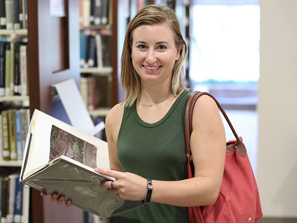 Student Holding Book in Library