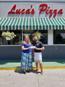 From left: Michelle Crook, DSLCC Foundation Board President accepts the donation from Marco Cucci of Cucci’s and Luca’s Pizza.