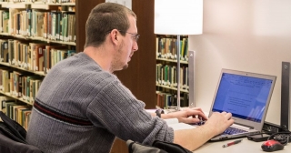 Male student studying at a computer