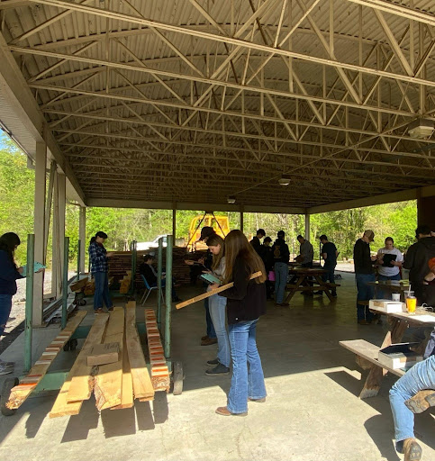 Students in tent with wood